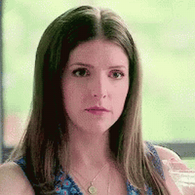 A Woman In A Blue Dress Is Holding A Glass Of Water . GIF