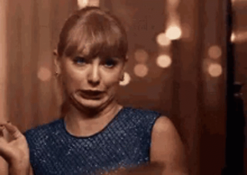 A Woman In A Blue Dress Is Making A Funny Face And Making A Funny Face . GIF
