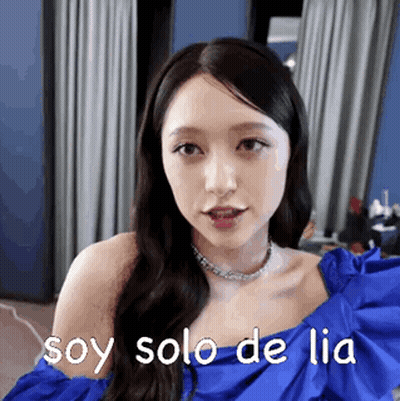 A Woman In A Blue Dress Is Making A Funny Face And Says `` Soy Solo De Lia '' . GIF