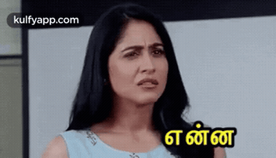 A Woman In A Blue Dress Is Making A Funny Face With A Foreign Language . GIF