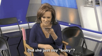 A Woman In A Blue Dress Is Sitting In A Chair Talking On A Cell Phone . GIF