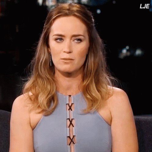 A Woman In A Blue Dress Is Sitting In A Chair With The Letters Lje Above Her GIF