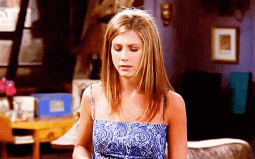 A Woman In A Blue Dress Is Sitting In A Living Room . GIF