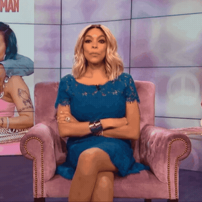 A Woman In A Blue Dress Is Sitting In A Pink Chair GIF