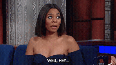 A Woman In A Blue Dress Is Sitting On A Couch And Saying `` Well , Hey . '' GIF