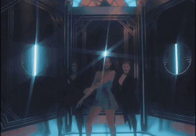 A Woman In A Blue Dress Is Standing In A Room With Two Other Women GIF