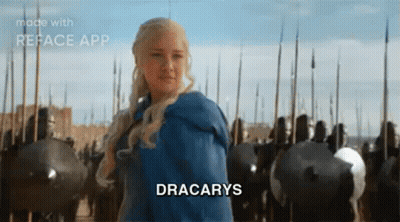 A Woman In A Blue Dress Is Standing In Front Of A Castle With A Sword In Her Hand . GIF