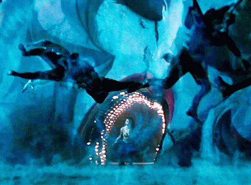 A Woman In A Blue Dress Is Standing In Front Of A Glowing Archway GIF