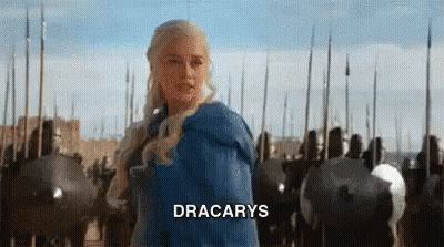 A Woman In A Blue Dress Is Standing In Front Of A Row Of Soldiers With The Word Dracarys On The Bottom . GIF