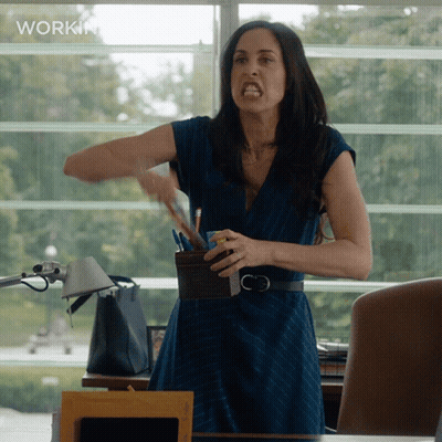 A Woman In A Blue Dress Is Standing In Front Of A Window With The Word Workin On The Bottom GIF