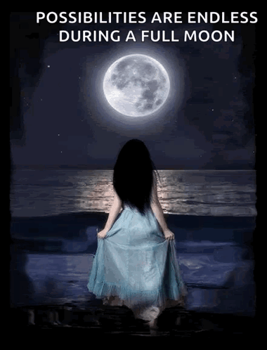 A Woman In A Blue Dress Is Standing On The Beach Looking At The Full Moon GIF