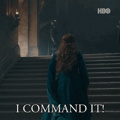 A Woman In A Blue Dress Is Walking Down A Set Of Stairs With The Words I Command It On The Bottom GIF