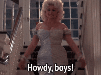 A Woman In A Blue Dress Says Howdy Boys While Standing On Stairs GIF