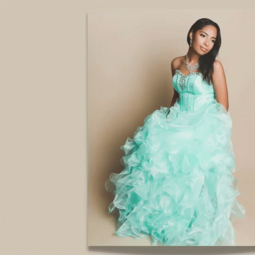 A Woman In A Blue Dress Stands In Front Of A Banner That Says Glam GIF