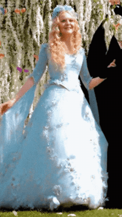 A Woman In A Blue Dress With A Blue Flower On Her Head GIF