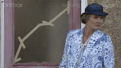 A Woman In A Blue Hat Stands In Front Of A Pink Door With An Arrow Drawn On It GIF