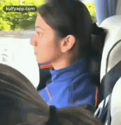 A Woman In A Blue Jacket Is Sitting In A Bus With A Man . GIF