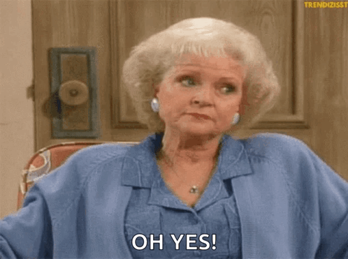 A Woman In A Blue Jacket Is Sitting In Front Of A Door And Says Oh Yes . GIF