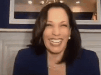 A Woman In A Blue Jacket Is Smiling In Front Of A Mirror . GIF