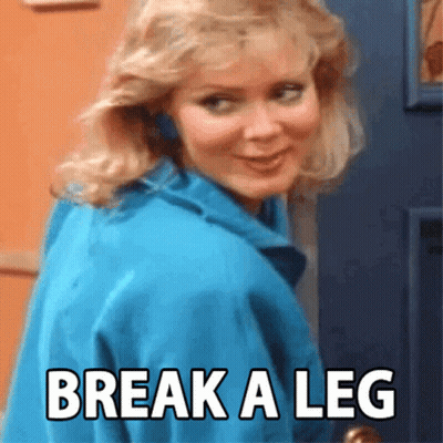 A Woman In A Blue Jacket Is Standing In Front Of A Door With The Words Break A Leg Written On It GIF