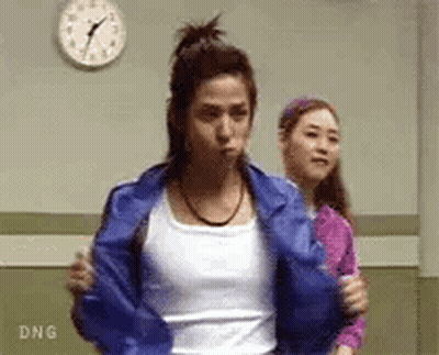 A Woman In A Blue Jacket Is Standing Next To Another Woman In A Pink Shirt . GIF