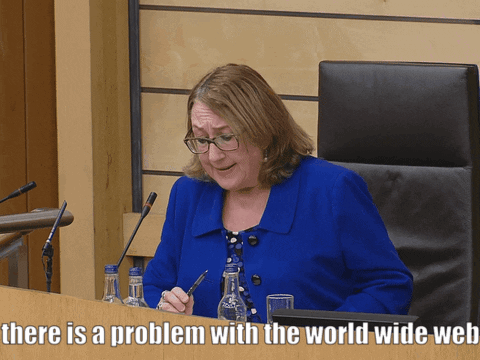 A Woman In A Blue Jacket Sits At A Desk With The Words There Is A Problem With The World Wide Web GIF