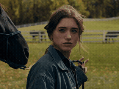 A Woman In A Blue Jacket Stands Next To A Horse GIF