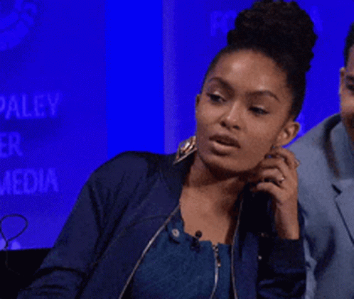 A Woman In A Blue Jacket Talks On A Phone GIF