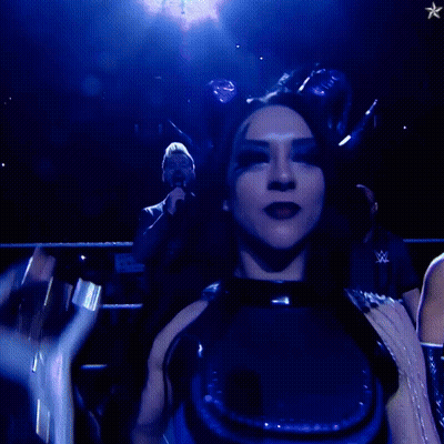 A Woman In A Blue Outfit Holds Up A Trophy GIF