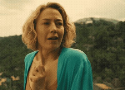 A Woman In A Blue Robe Stands In Front Of Mountains GIF