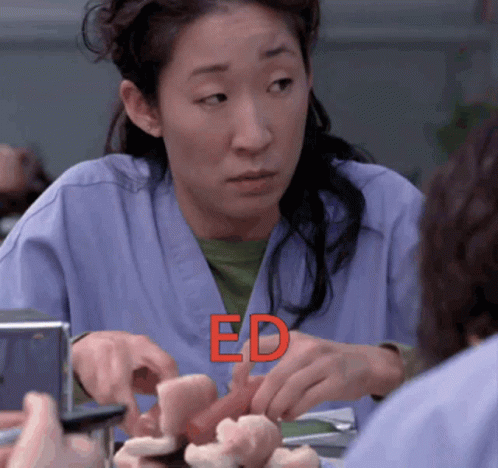 A Woman In A Blue Scrub Is Holding A Piece Of Meat And The Word Ed Is Visible In Red GIF