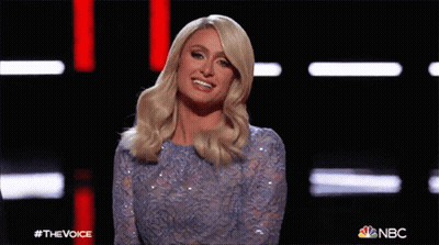 A Woman In A Blue Sequined Dress Is Waving At The Camera On Nbc 'S The Voice Show GIF