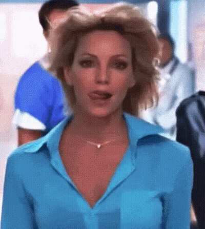 A Woman In A Blue Shirt And Necklace Is Talking To Someone GIF