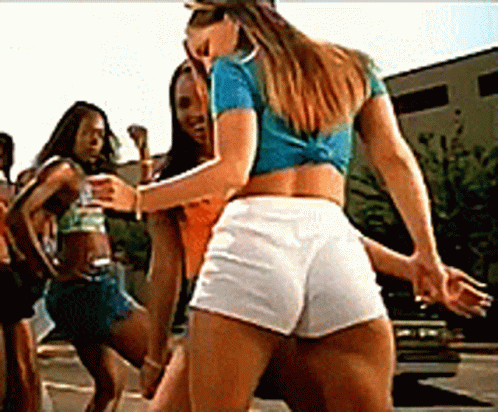A Woman In A Blue Shirt And White Shorts Is Dancing With Two Other Women GIF