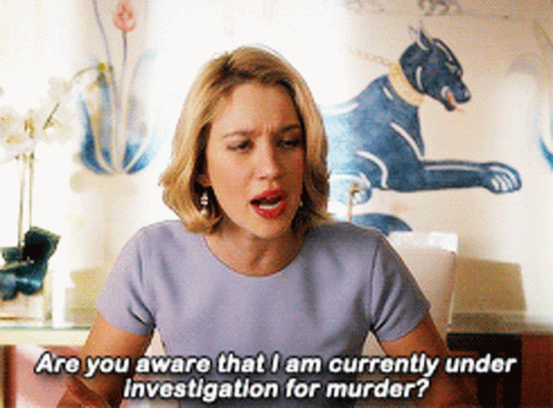A Woman In A Blue Shirt Is Asking If She Is Currently Under Investigation For Murder GIF