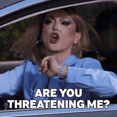 A Woman In A Blue Shirt Is Driving A Car And Says Are You Threatening Me GIF