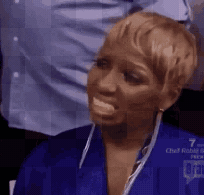 a woman in a blue shirt is making a funny face with her mouth open .