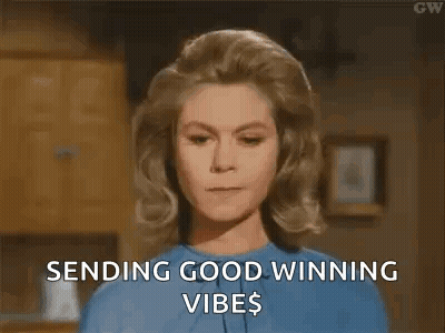 A Woman In A Blue Shirt Is Sending Good Winning Vibes To Someone . GIF