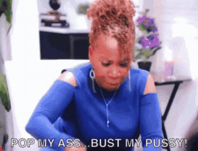 A Woman In A Blue Shirt Is Sitting At A Table And Says Pop My Ass Bust My Pussy . GIF