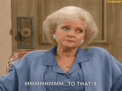 A Woman In A Blue Shirt Is Sitting In Front Of A Door And Says " Mmmmmhmm ... To That ! " GIF