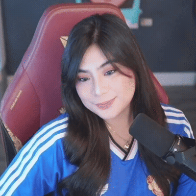 A Woman In A Blue Shirt Is Sitting In Front Of A Microphone . GIF
