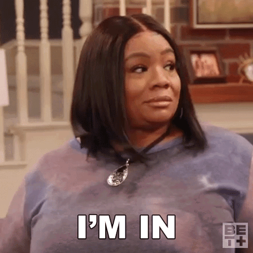 A Woman In A Blue Shirt Is Sitting On A Couch And Says `` I 'M In '' . GIF