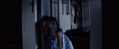 A Woman In A Blue Shirt Is Standing In A Dark Room With The Words " By Diablito " On The Bottom GIF