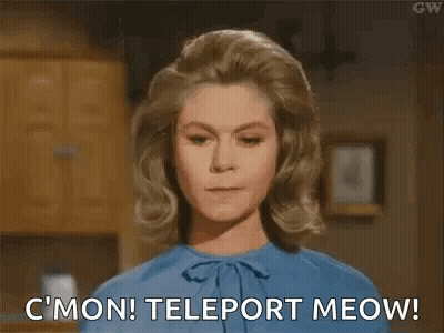 A Woman In A Blue Shirt Is Standing In A Kitchen . GIF