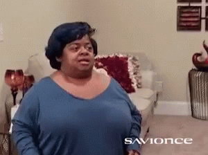A Woman In A Blue Shirt Is Standing In A Living Room With The Word Savonce On The Bottom GIF