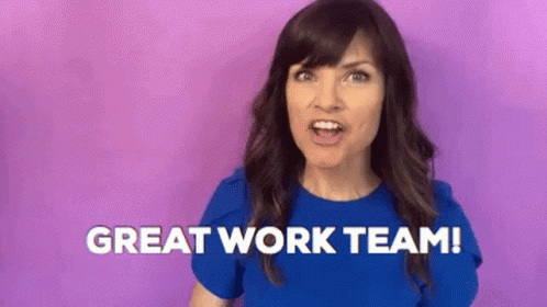 A Woman In A Blue Shirt Is Standing In Front Of A Purple Background And Saying `` Great Work Team '' . GIF