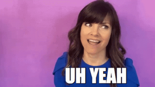 A Woman In A Blue Shirt Is Standing In Front Of A Purple Background And Saying Uh Yeah . GIF