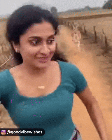 A Woman In A Blue Shirt Is Walking Down A Dirt Road With The Caption Goodvibewishes GIF