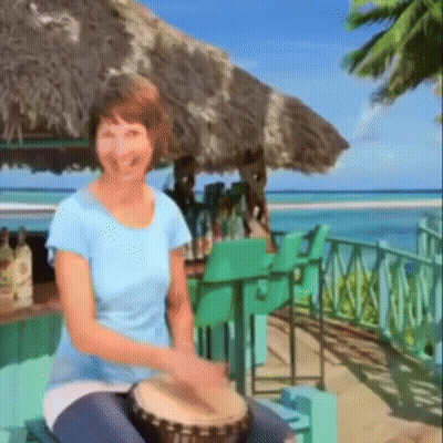 A Woman In A Blue Shirt Playing A Drum GIF