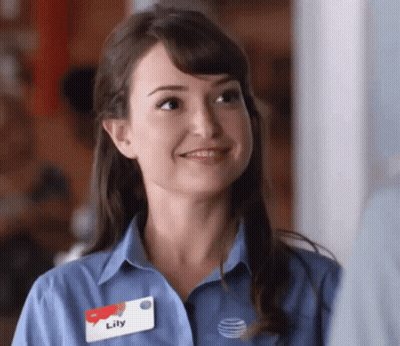 A Woman In A Blue Shirt With A Name Tag That Says Lily GIF